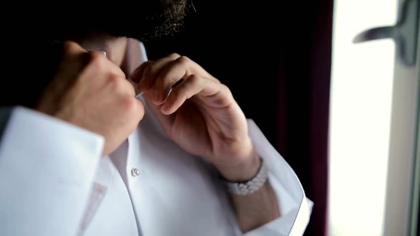 Shot of Elegant business man correcting his tie and buttoning his suit. A businessman dresses his own elegant suit. Person hands buttons up his blazer.