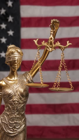 Golden Statue of Justice with American flag background