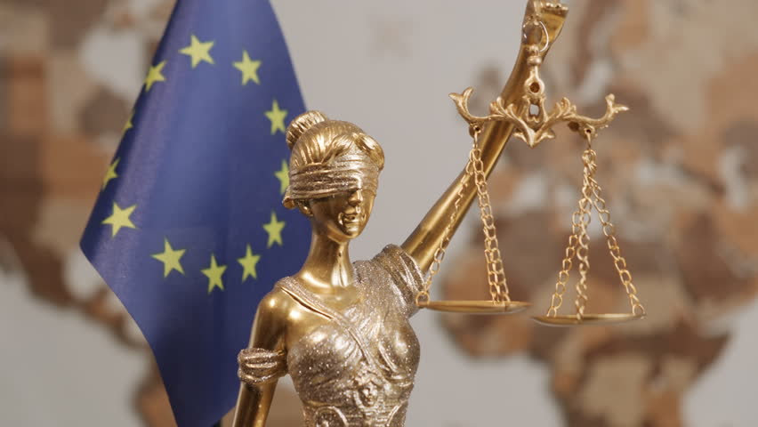 Themis statue with scales of justice with European Union flag on background of world map