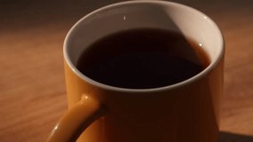 Hand drops sugar cube into cup of black tea and stirring - Powered by Shutterstock - Get 15% off with code: PIKWIZARD15