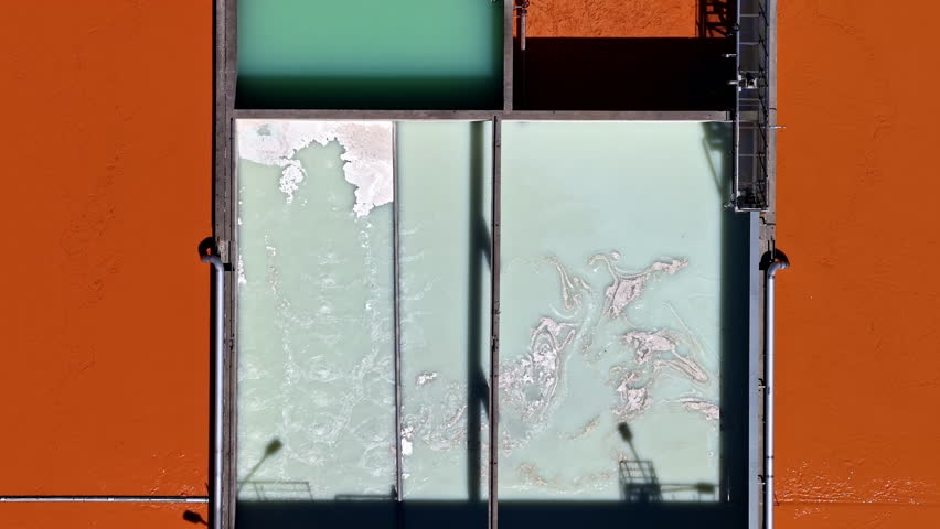 Tracking shot over wastewater treatment system with angular layout and color changes