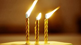 close-up of time-lapse video of three candles melting, their flames casting a warm glow, standing on a dark surface against a deep black background.  - Powered by Shutterstock - Get 15% off with code: PIKWIZARD15