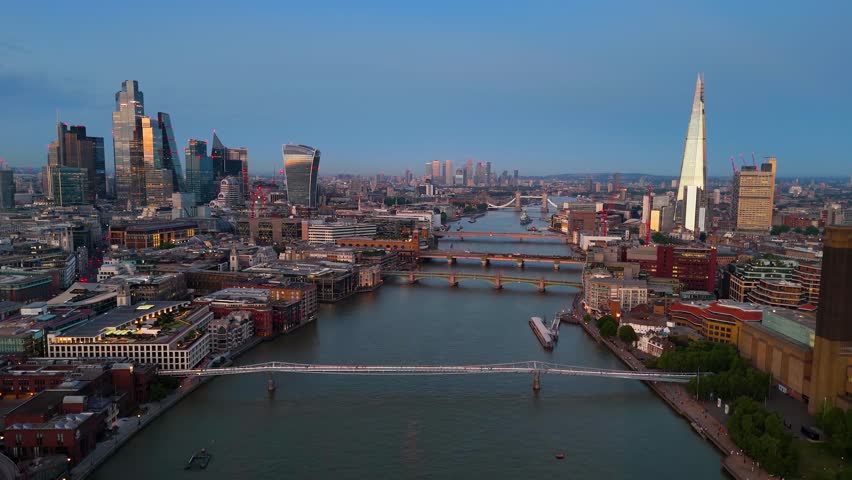 Aerial view of the illuminated central London skyline with River Thames, City skyscrapers and the various bridges during dusk