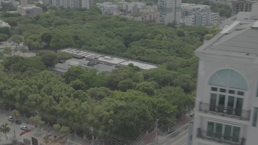 Santo Domingo, Dominican Republic – June 22, 2025: Aerial drone footage capturing a large modern building with the city skyline of Santo Domingo in the background, 4k raw color video.