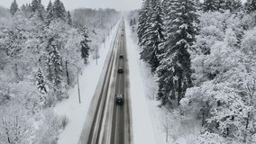 Aerial view of road with cars driving through winter forest with snow. Concept of dangerous driving on slippery and snowy road - Powered by Shutterstock - Get 15% off with code: PIKWIZARD15