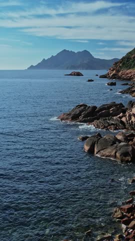Aerial view from a high point, showcasing the vast expanse of the ocean along the coastline of Corsica, France.