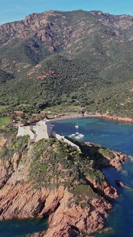 A vast body of water encircled by towering mountains in Corsica, France.