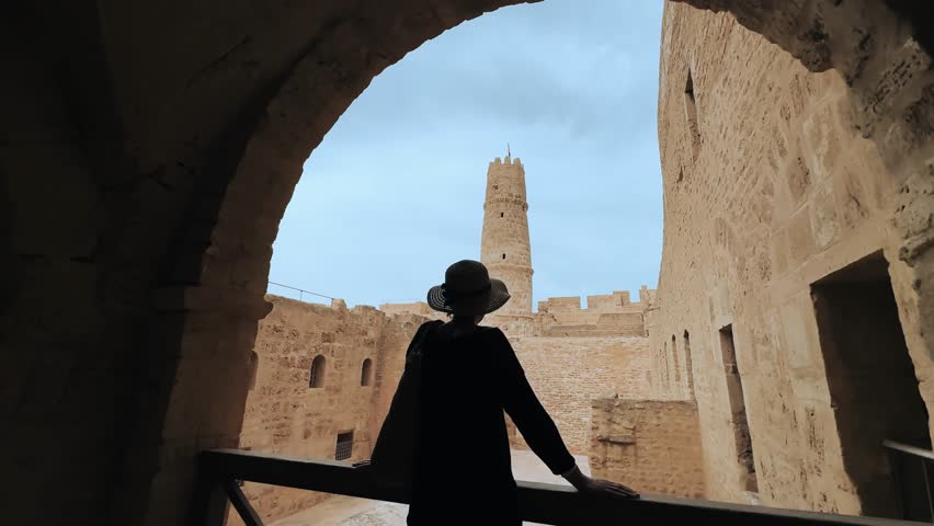 Woman Silhouetted in Historic Monastir Ribat in Monastir, Tunisia with Tower in Background