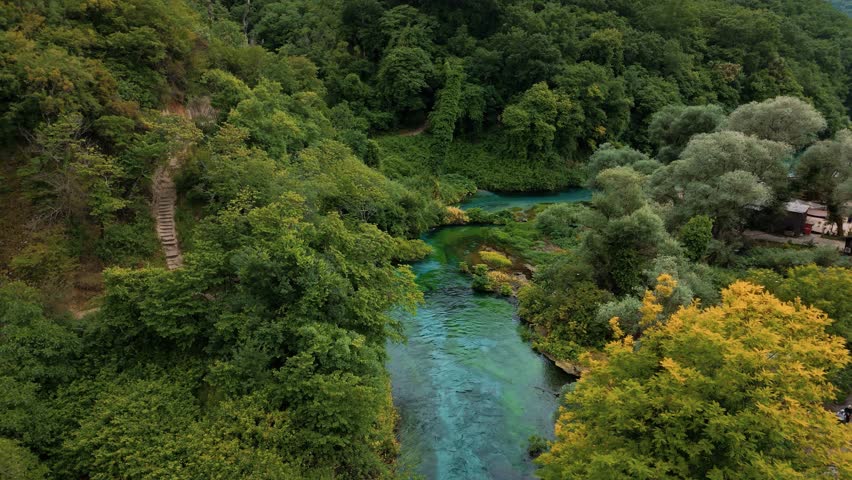 Turquoise water of Syri i Kaltër, Albania’s Blue Eye, seen from above in a peaceful forest setting
