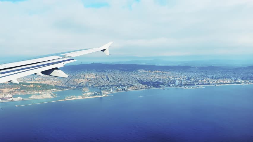 Airplane flight landing in Barcelona with view of coastline sea and cityscape