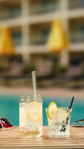Fruit cocktail in hotel bar, Two cocktail glasses cheers in the hands on sea background. Bartenter making drink in bar, Summer vacation concept, A beautiful couple enjoy the vacation at the beach.