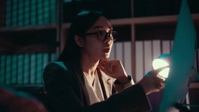 Young Asian businesswoman wearing headset working overtime late at night at office, using computer to talk with customer, online meeting, video call, support, service, assistance - Powered by Shutterstock - Get 15% off with code: PIKWIZARD15