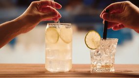 Fruit cocktail in hotel bar, Two cocktail glasses cheers in the hands on sea background. Bartenter making drink in bar, Summer vacation concept, A beautiful couple enjoy the vacation at the beach. - Powered by Shutterstock - Get 15% off with code: PIKWIZARD15