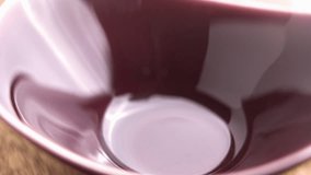 Roasted Arabica coffee beans falling into a red ceramic bowl in slow motion on wooden table. Macro shot - Powered by Shutterstock - Get 15% off with code: PIKWIZARD15