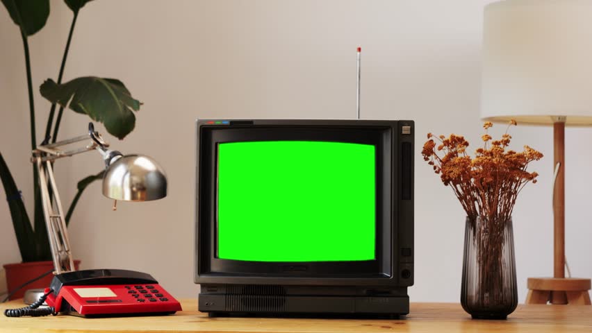 Retro TV, vintage television In a nostalgic setup, a retro TV displays grain on screen, scary halloween night device good for chroma key and green screen.