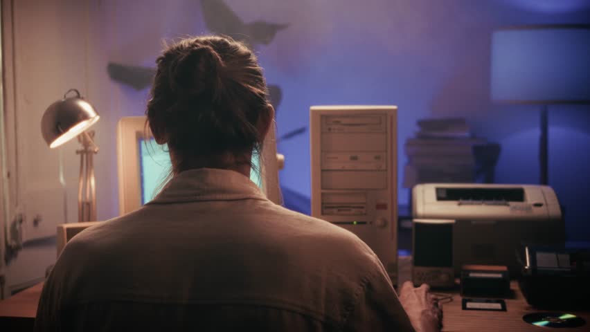 Man working and gaming on retro computer PC, IT engineer with vintage computer at home, using old fashion technology, close up of retro setup. 