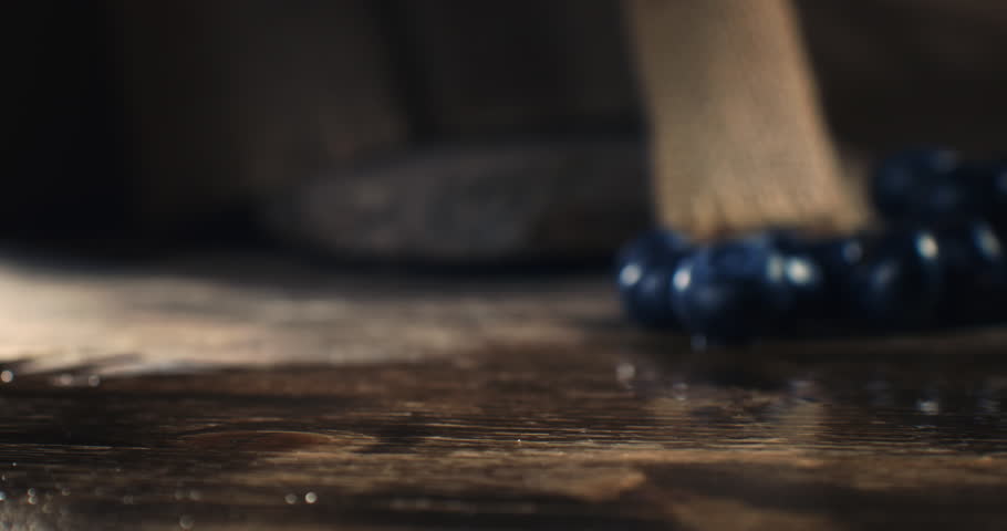 Super Slow Motion of Juicy Blueberries Hitting the Wooden Surface Splashing with Tiny Droplets Under Warm Light, Highlighting Their Freshness, Texture and Natural Movement in Cinematic Scene, 1000 fps