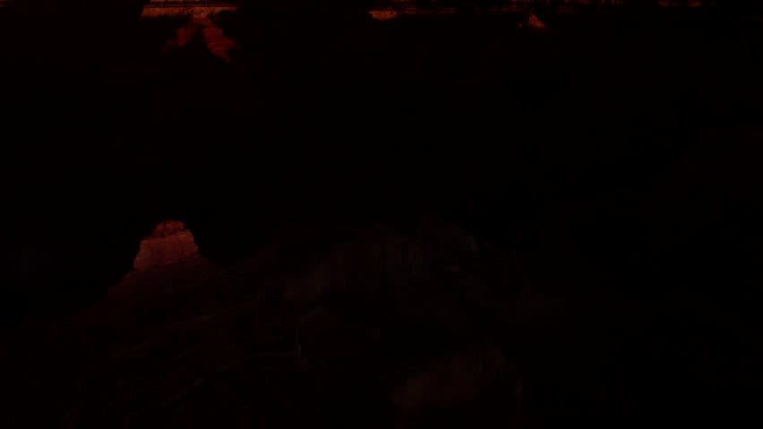 Day breaks from darkness and deep shadows to fill the Grand Canyon with rich morning sunlight.