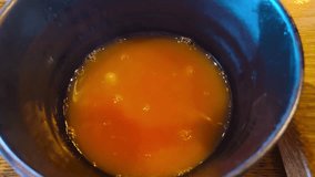 Close-up view of hot rich steaming tomato soup being poured into a black empty bowl at a Chinese Asian restaurant. Warm comforting diner with traditional flavors authentic cuisine cozy atmosphere. - Powered by Shutterstock - Get 15% off with code: PIKWIZARD15