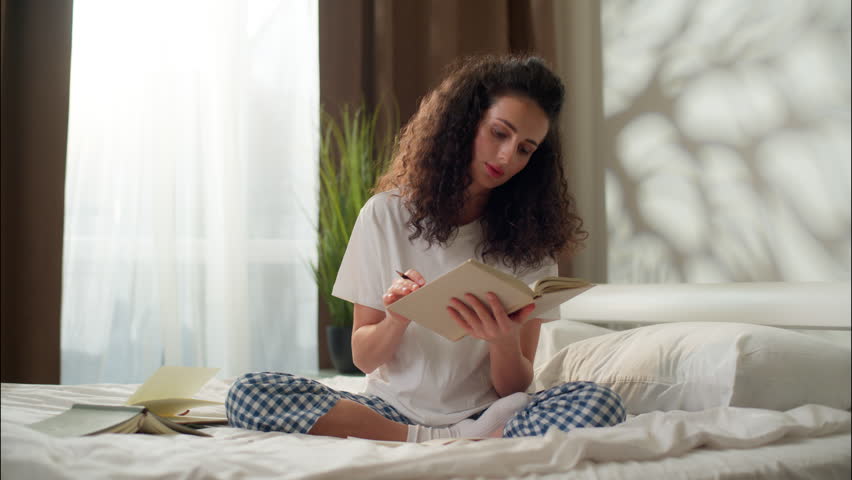 Woman reading book in bed thoughtful girl studying thinking idea in bedroom morning home education writing in notebook female student businesswoman prepare homework write notes comfort study knowledge
