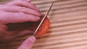 Cutting the cherry tomatoes in slow motion with a knife on a wooden board. Tomato in half. Cut vegetables with a top view. Slow motion cooking video. Fresh italian recipe with tomato juice - Powered by Shutterstock - Get 15% off with code: PIKWIZARD15