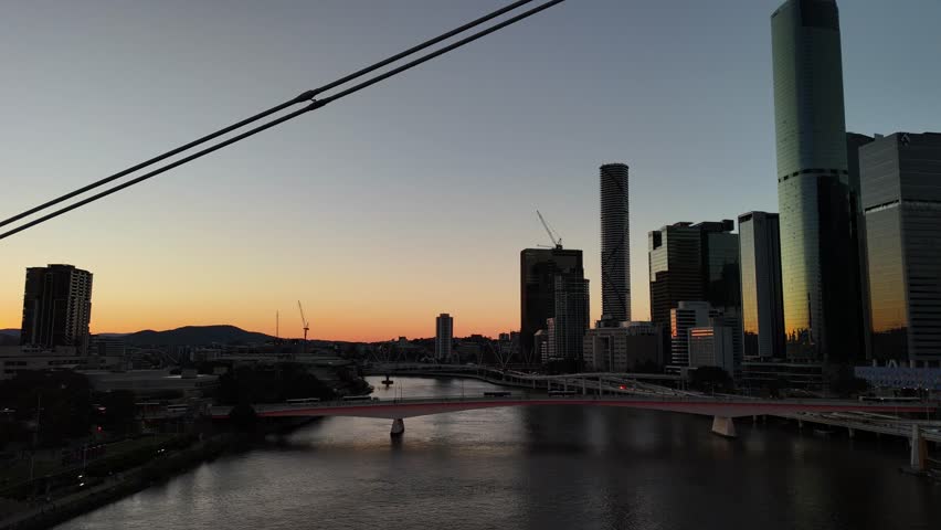 Brisbane CBD, Queensland, Australia: 4K Aerial Sunset Image Featuring City Skyline, Skyscrapers, Brisbane River, The Wheel of Brisbane, and South Bank Cultural Precinct in Warm Evening Light