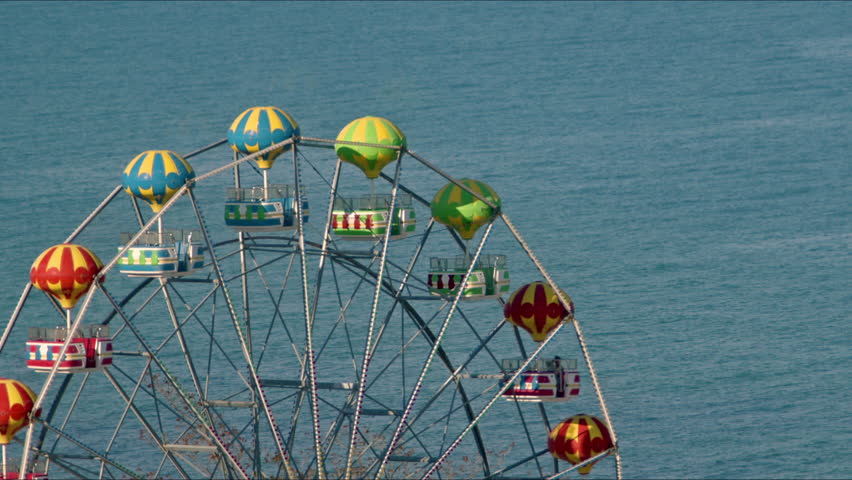 Empty Spinning Ferris Wheel on Calm Ocean Background Footage.
