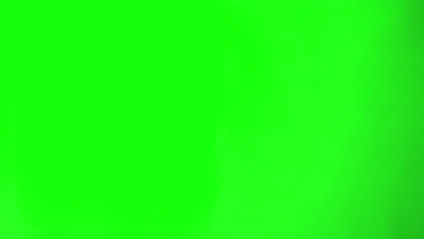 Hand holding scissors and cutting from above. green screen background