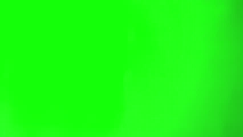 Hand holding scissors and cutting from above. green screen background