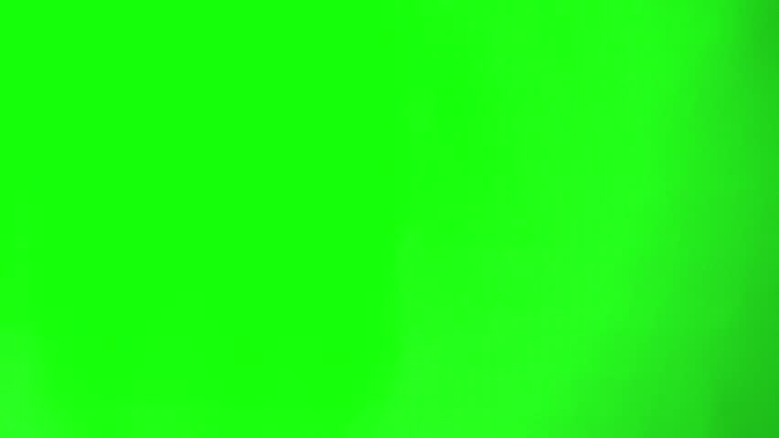 Hand holding scissors and cutting from below. green screen background