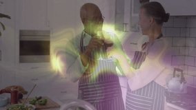 Mature couple finishing cooking meal on countertop in kitchen, pouring red wine and toasting. Romance, celebration, connection, domestic, lifestyle, home, conviviality - Powered by Shutterstock - Get 15% off with code: PIKWIZARD15