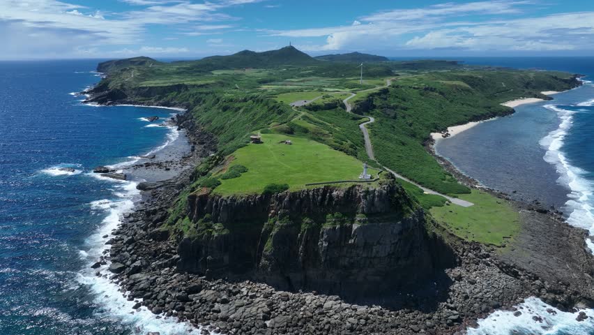 This aerial footage captures the panoramic view of Yonaguni Island, Japan’s westernmost point. The vibrant turquoise sea, rugged cliffs, and vast horizon blend into a breathtaking landscape. Near the 