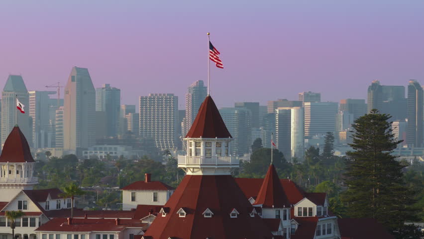 Aerial footage beautifully showcases the iconic Hotel Del Coronado as it stands majestically against the picturesque San Diego skyline, highlighting its remarkable architecture and vibrant colors