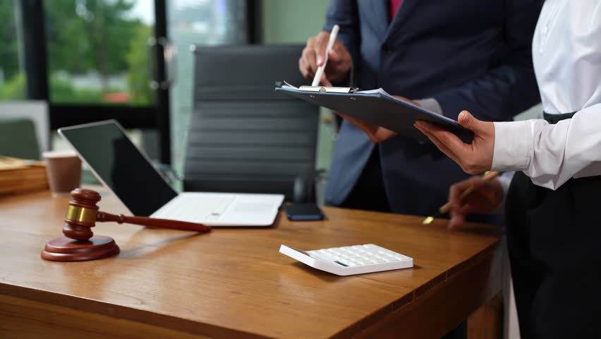 Businessman or Legal counsel working with paperwork on his desk in office workplace working with tablet computer. Justice and law concept.