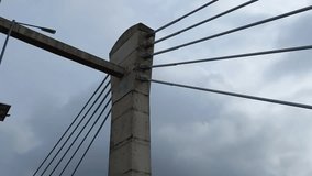 A close-up view of a cable-stayed bridge structure against a cloudy sky. The primary focus is on a concrete pillar. - Powered by Shutterstock - Get 15% off with code: PIKWIZARD15