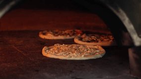 4k pizza wood oven video. Pizzas baking inside a hot wood-fired oven. Open flames and rustic interior highlight traditional artisan cooking methods. Italian wooden fire artigianale pizza. - Powered by Shutterstock - Get 15% off with code: PIKWIZARD15