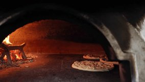 4k pizza wood oven video. Pizzas baking inside a hot wood-fired oven. Open flames and rustic interior highlight traditional artisan cooking methods. Italian wooden fire artigianale pizza. - Powered by Shutterstock - Get 15% off with code: PIKWIZARD15
