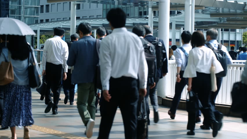 Lots of commuters going to work during busy morning rush hour. Slow motion.