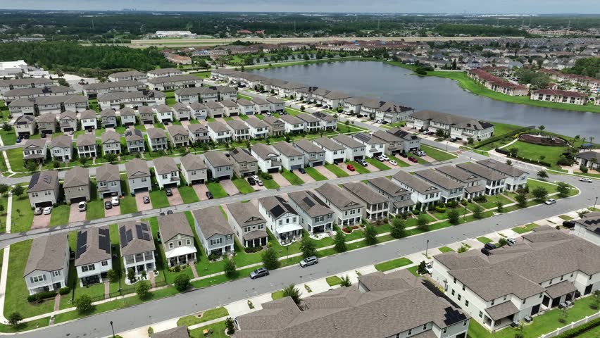 Aerial view of modern housing development in Orlando, Florida, with rows of contemporary homes alongside a serene lake. Suburban living with natural beauty. aerial view. Two story homes in USA.