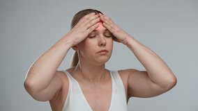 A woman is holding her hands on her head highlighted with a red area, indicating pain, stress, or trauma. The concept of health, healing and pain relief. - Powered by Shutterstock - Get 15% off with code: PIKWIZARD15