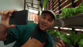 Proud man selfie photo or video call growing vegetables in a vertical garden on his apartment balcony, an urban lifestyle with homegrown food and sustainable living in limited spa - Powered by Shutterstock - Get 15% off with code: PIKWIZARD15