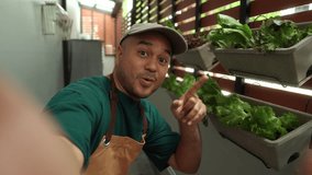 Proud man selfie photo or video call growing vegetables in a vertical garden on his apartment balcony, an urban lifestyle with homegrown food and sustainable living in limited spa - Powered by Shutterstock - Get 15% off with code: PIKWIZARD15