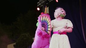 Exciting performances unfold as talented drag queen and a man in a unicorn costume with rainbow mane showcase their artistry at a queer pride event, creating a festive atmosphere. - Powered by Shutterstock - Get 15% off with code: PIKWIZARD15