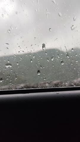 Video footage of Rain drops falling on car without glass during rain storm close up ,  Rainy weather at daylight outdoor - udaipur rajasthan india , june 
