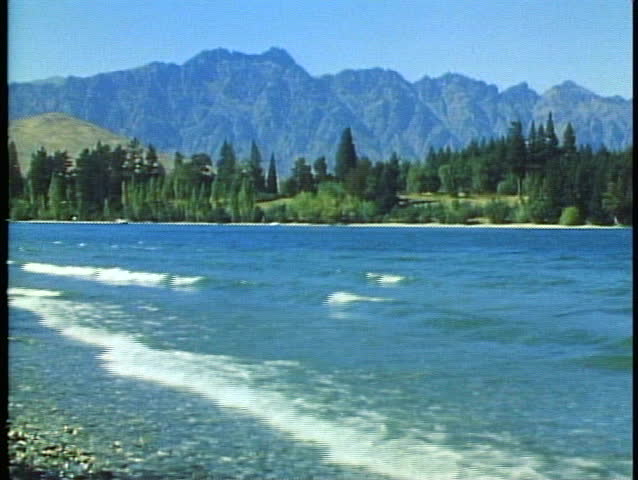 Queenstown, New Zealand, mountain lake, surf rolling in, mountains in background