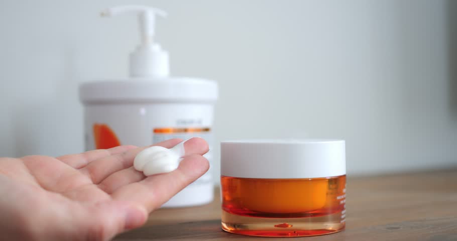 Cream dollop on fingertip against blurred jar background, highlighting whipped formulation and smooth texture, scene ideal for beauty tutorials and cosmetic advertising.