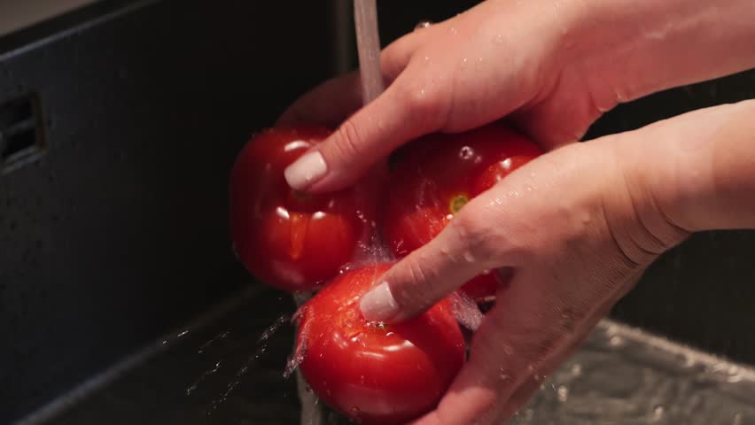 Close of a woman washing tomatoes with tap water. Clean, natural products from organic farming. High quality 4k footage