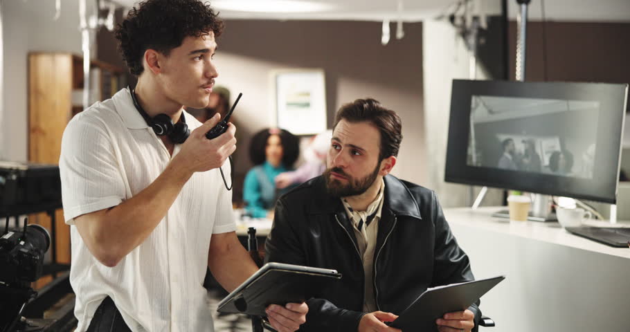 Movie production, men and conversation on set, director and advice with radio, tablet and creative. People, employees and digital tech with screen, ideas and editing with film shooting and teamwork