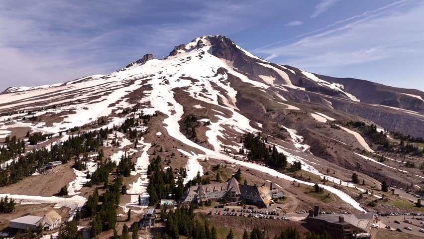 Mount Hood and summer ski slope area, with the ski lodge in the foreground. Clear sky and sunshine