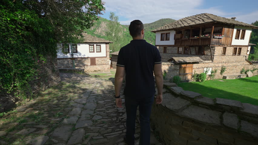 Man Walking In The Street In Kovachevitsa Mountain Village In Bulgaria. - wide shot